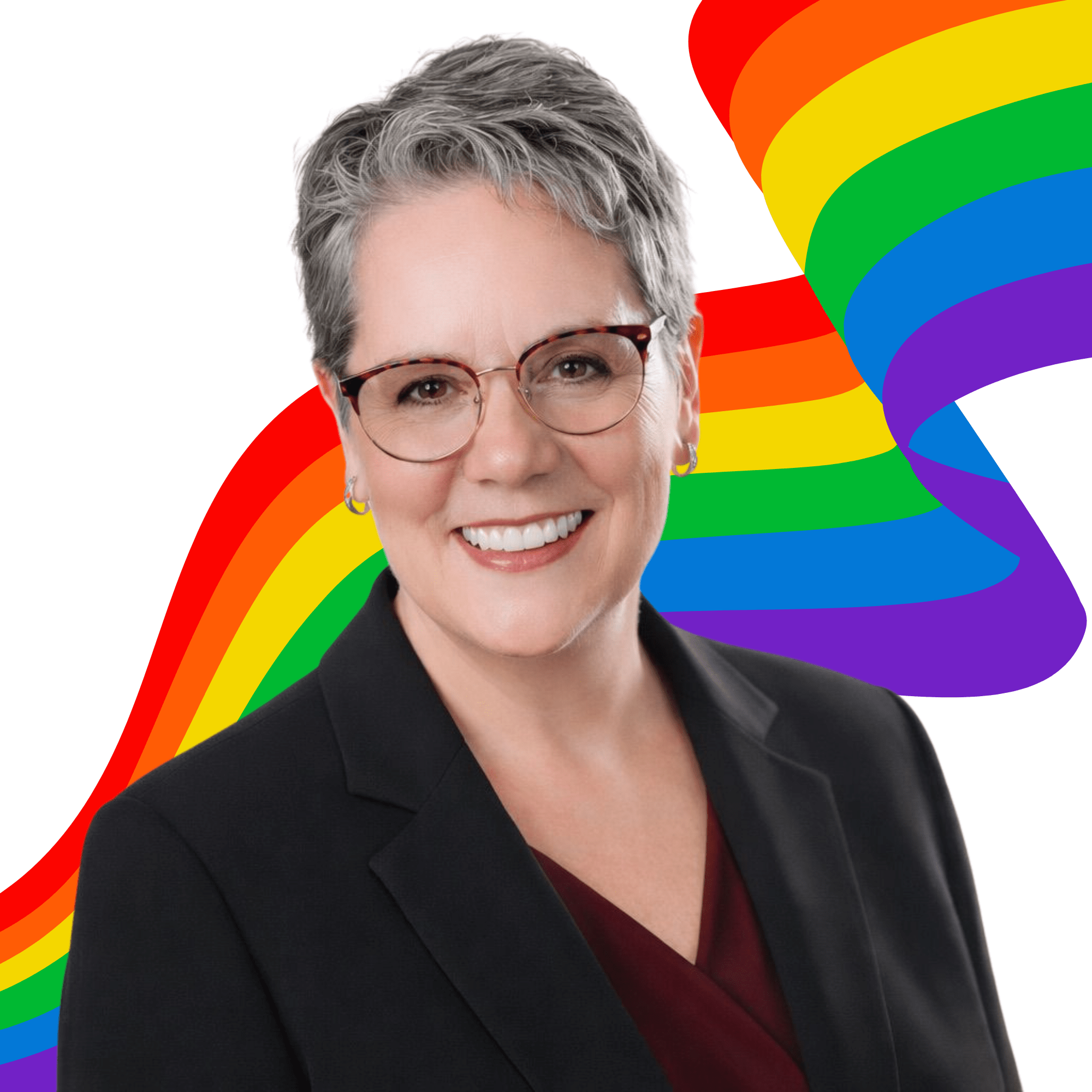 Untitled design (2) Smiling person with short gray hair, glasses, and a dark blazer stands in front of a colorful rainbow ribbon on a white background.